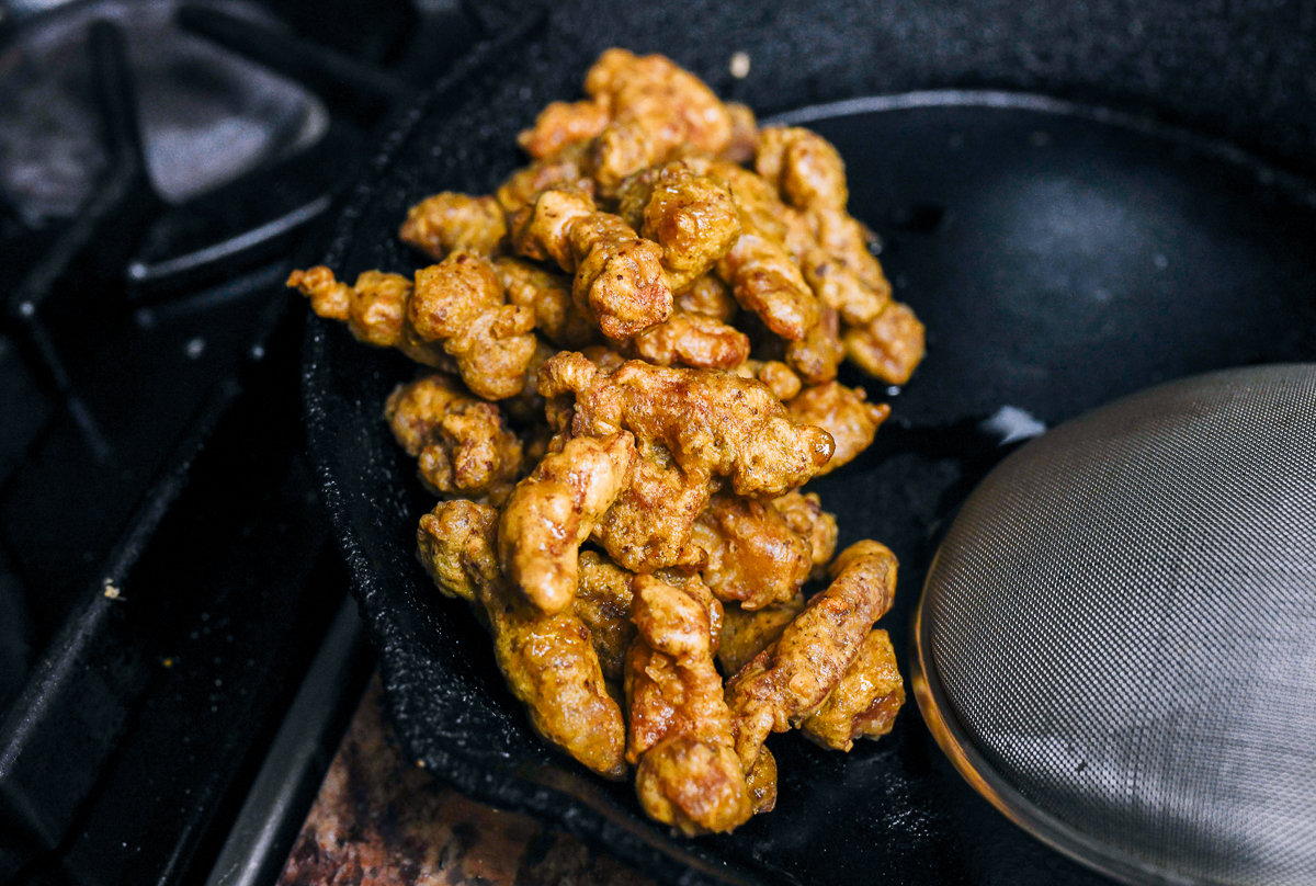 fried pork pieces in cast iron pan
