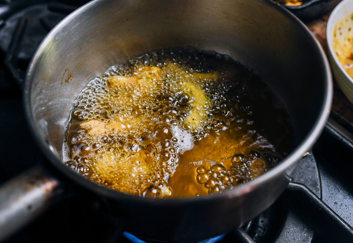 frying battered pork pieces in oil