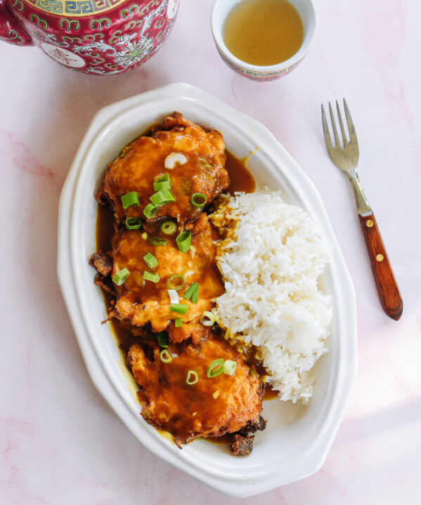 Pork egg foo young on a plate with gravy and rice