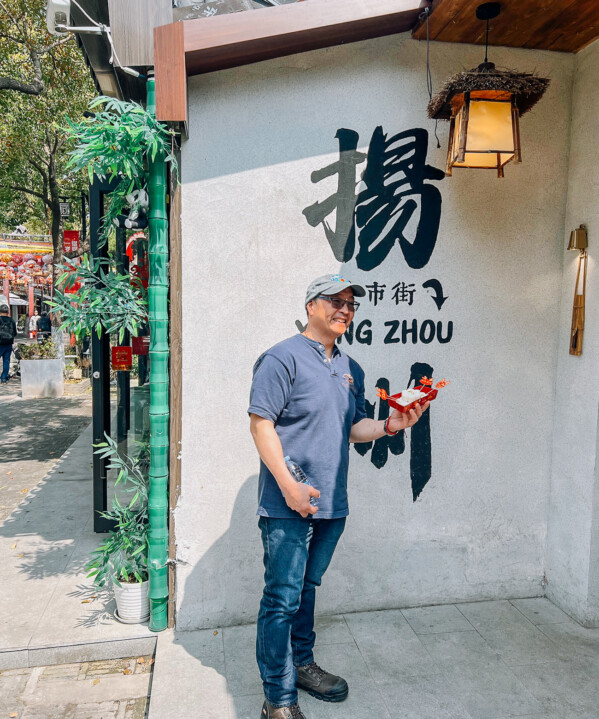 Bill in front of Yangzhou sign